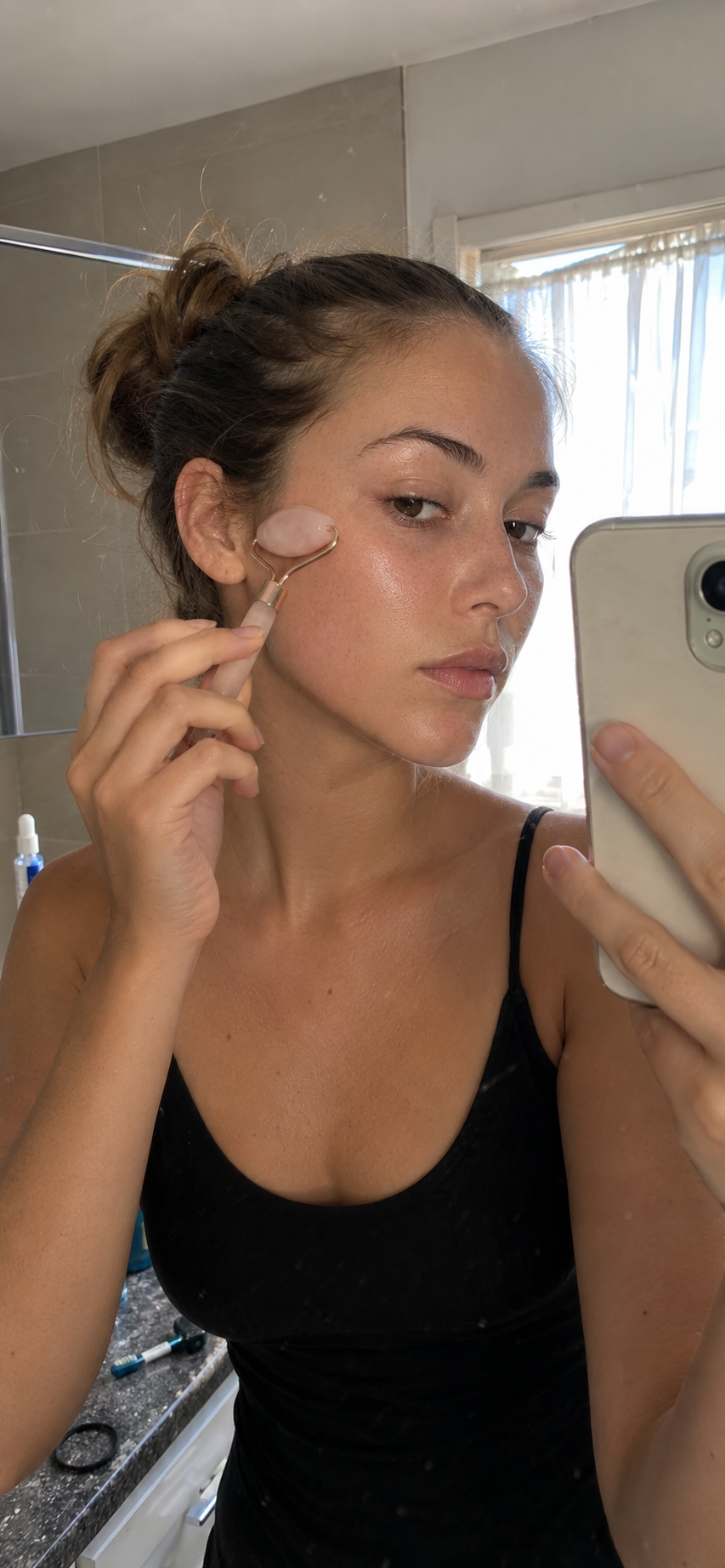 Model using a face roller in natural sunlight